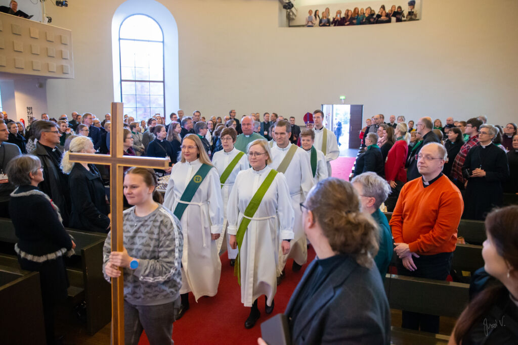 Messun ristikulkue kulkee ihmisten katsoessa Hämeenlinnan kirkon keskikäytävää kohti alttaria. 