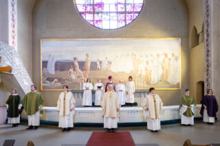 Pappisvirkaan vihittyjä seisomassa alttarin edessä yllään kasukat