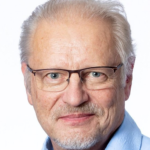 Kalle Mäki vaaleansininen paita yllään katsoo kameraan hymyillen.